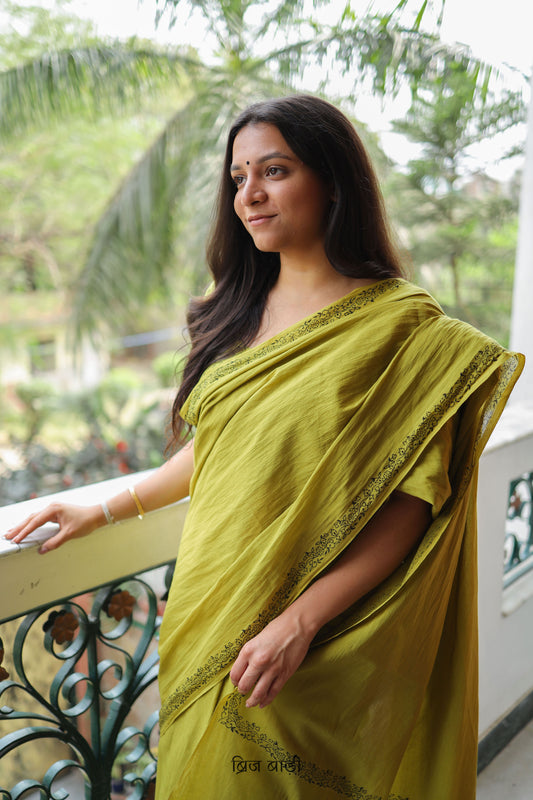 Light green soft and light-weight cotton saree by Brij Bari with a simple & elegant hand block printed border in classic black. Crafted in breathable, airy cotton, this saree is ideal for everyday wear — offering ease, comfort, and timeless style for work, casual days or relaxed occasions. The pallu is beautifully finished with purple handmade thread tassels, adding a playful, artisanal touch. It comes with a free hand block printed blouse piece