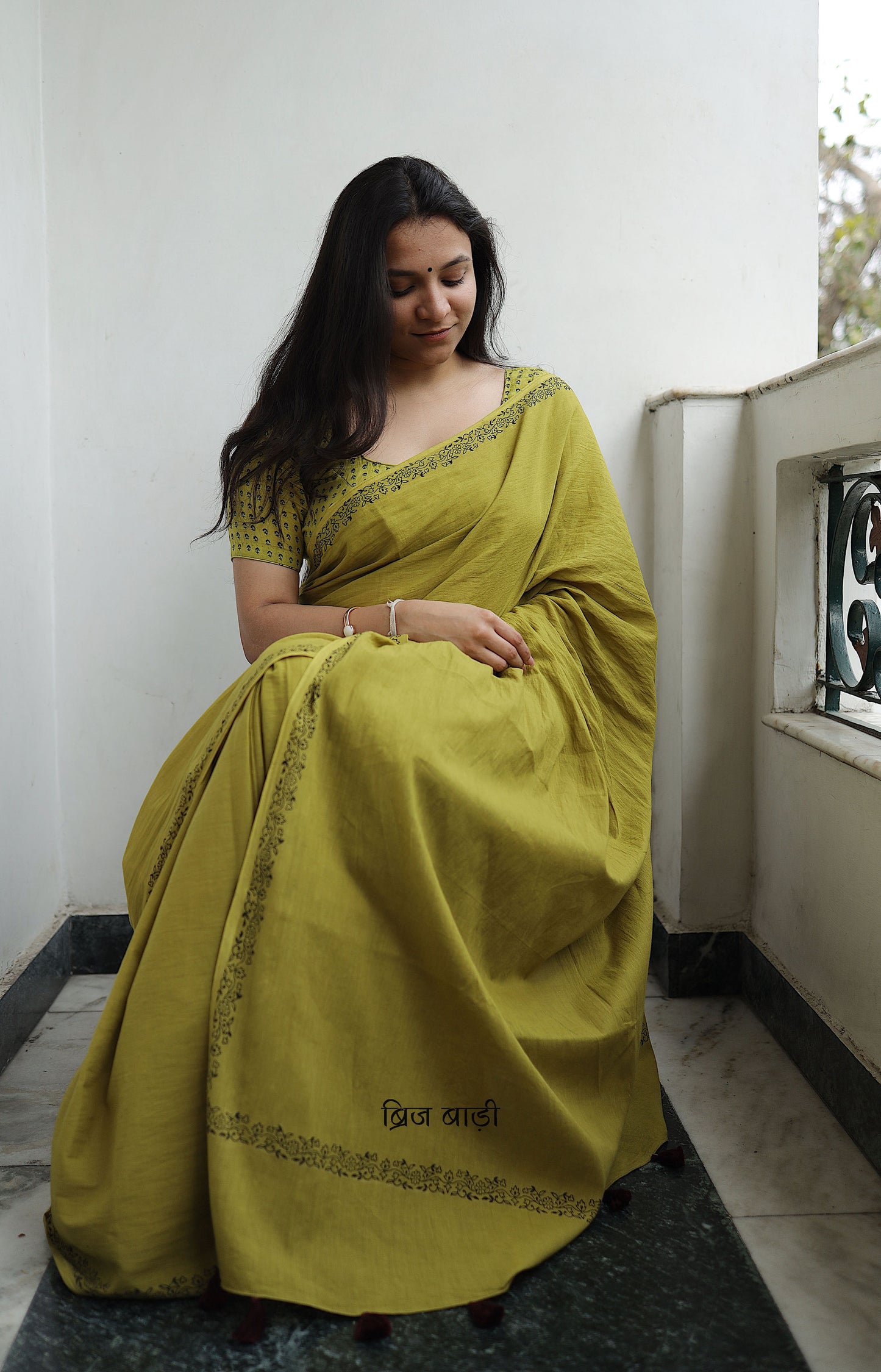 Light green soft and light-weight cotton saree by Brij Bari with a simple & elegant hand block printed border in classic black. Crafted in breathable, airy cotton, this saree is ideal for everyday wear — offering ease, comfort, and timeless style for work, casual days or relaxed occasions. The pallu is beautifully finished with purple handmade thread tassels, adding a playful, artisanal touch. It comes with a free hand block printed blouse piece