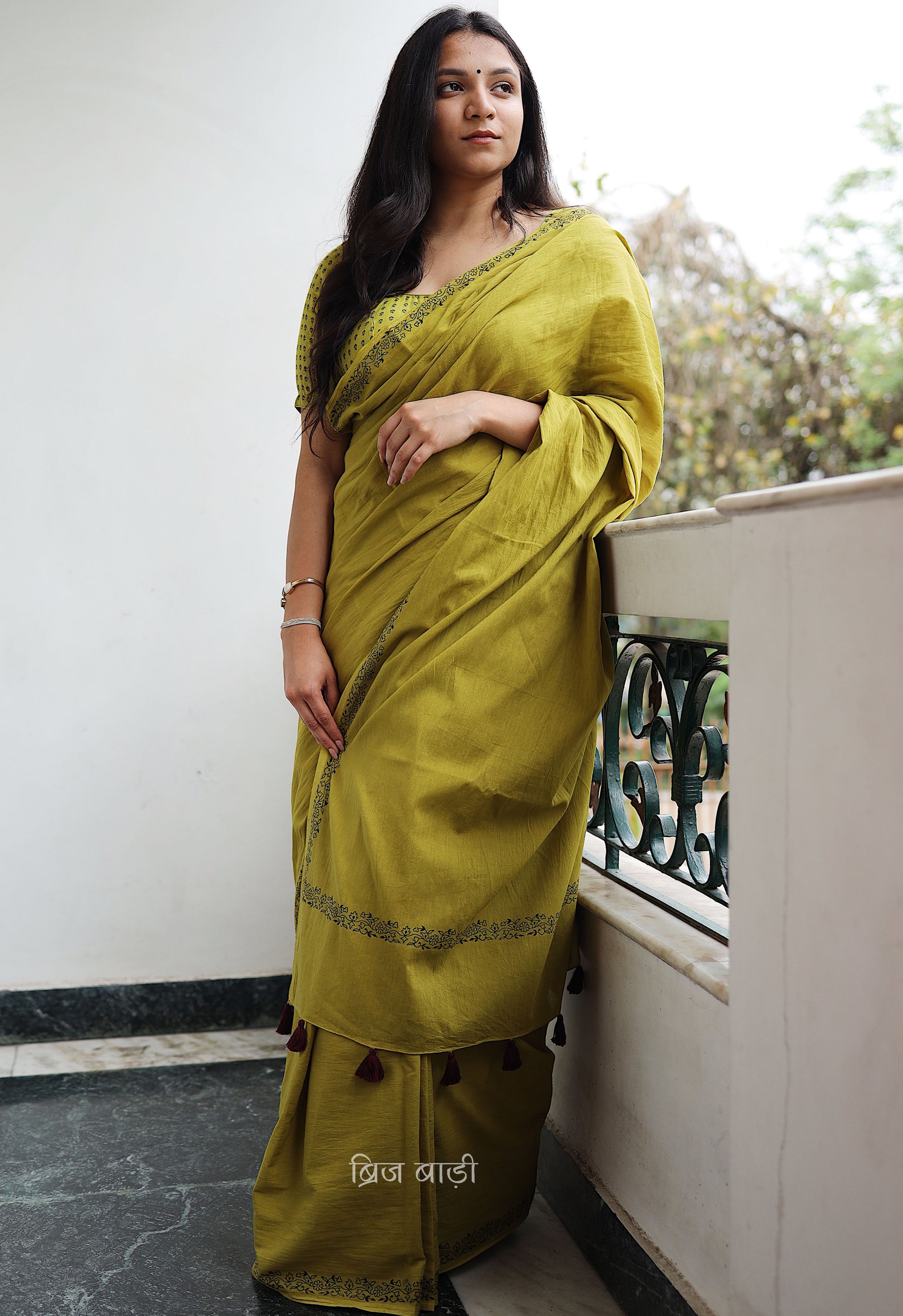 Light green soft and light-weight cotton saree by Brij Bari with a simple & elegant hand block printed border in classic black. Crafted in breathable, airy cotton, this saree is ideal for everyday wear — offering ease, comfort, and timeless style for work, casual days or relaxed occasions. The pallu is beautifully finished with purple handmade thread tassels, adding a playful, artisanal touch. It comes with a free hand block printed blouse piece