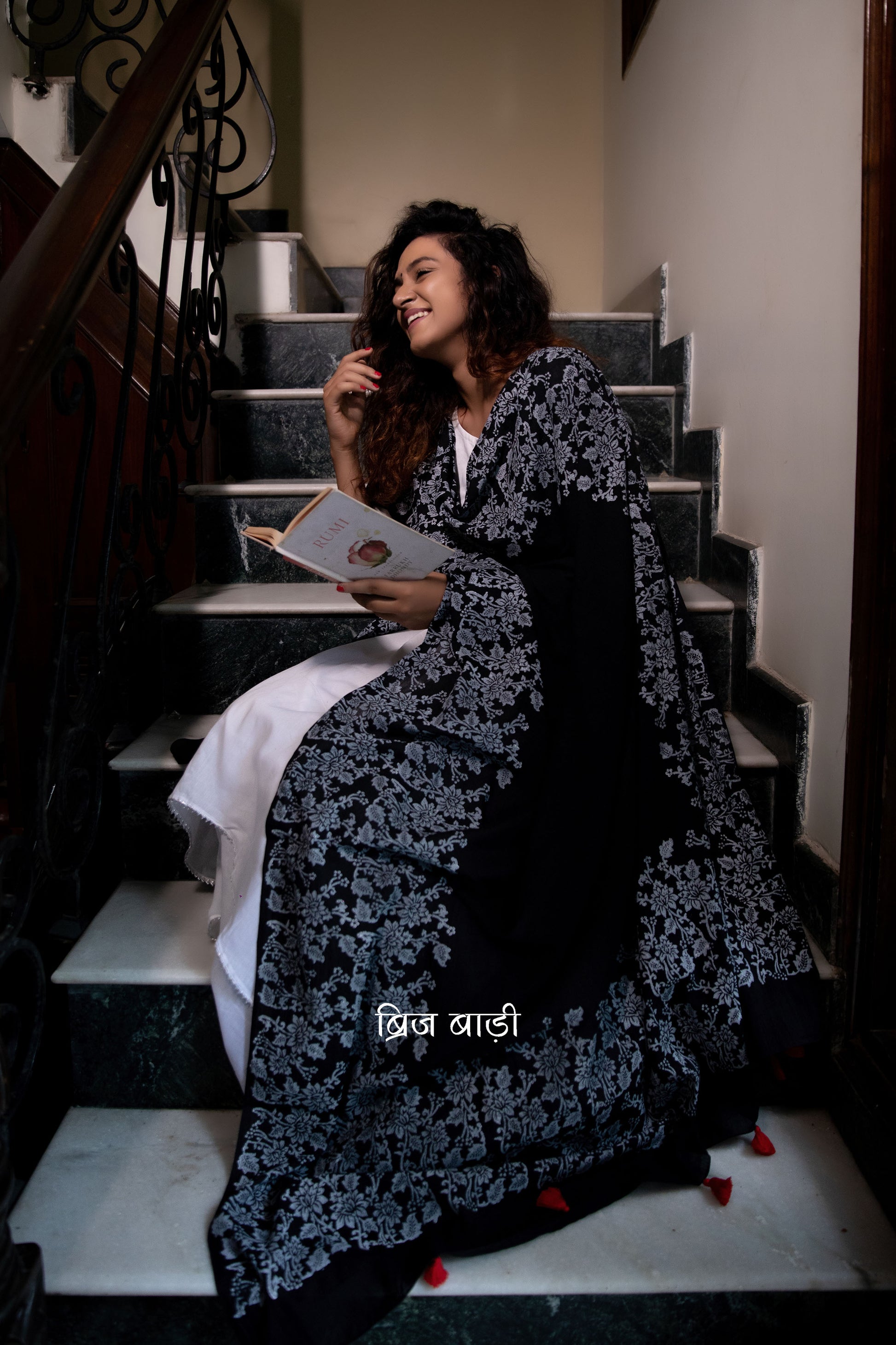 Black soft and light-weight cotton dupatta by Brij Bari, adorned with an elegant floral border hand block printed in white, creating a striking contrast against the deep black base. Crafted from breathable, airy cotton fabric, this dupatta is ideal to pair with suits, kurtas, or ethnic sets, adding a refined handcrafted touch to both everyday and occasion wear. The pallu is finished with vibrant red handmade thread tassels, offering a playful, artisanal accent to the look. 