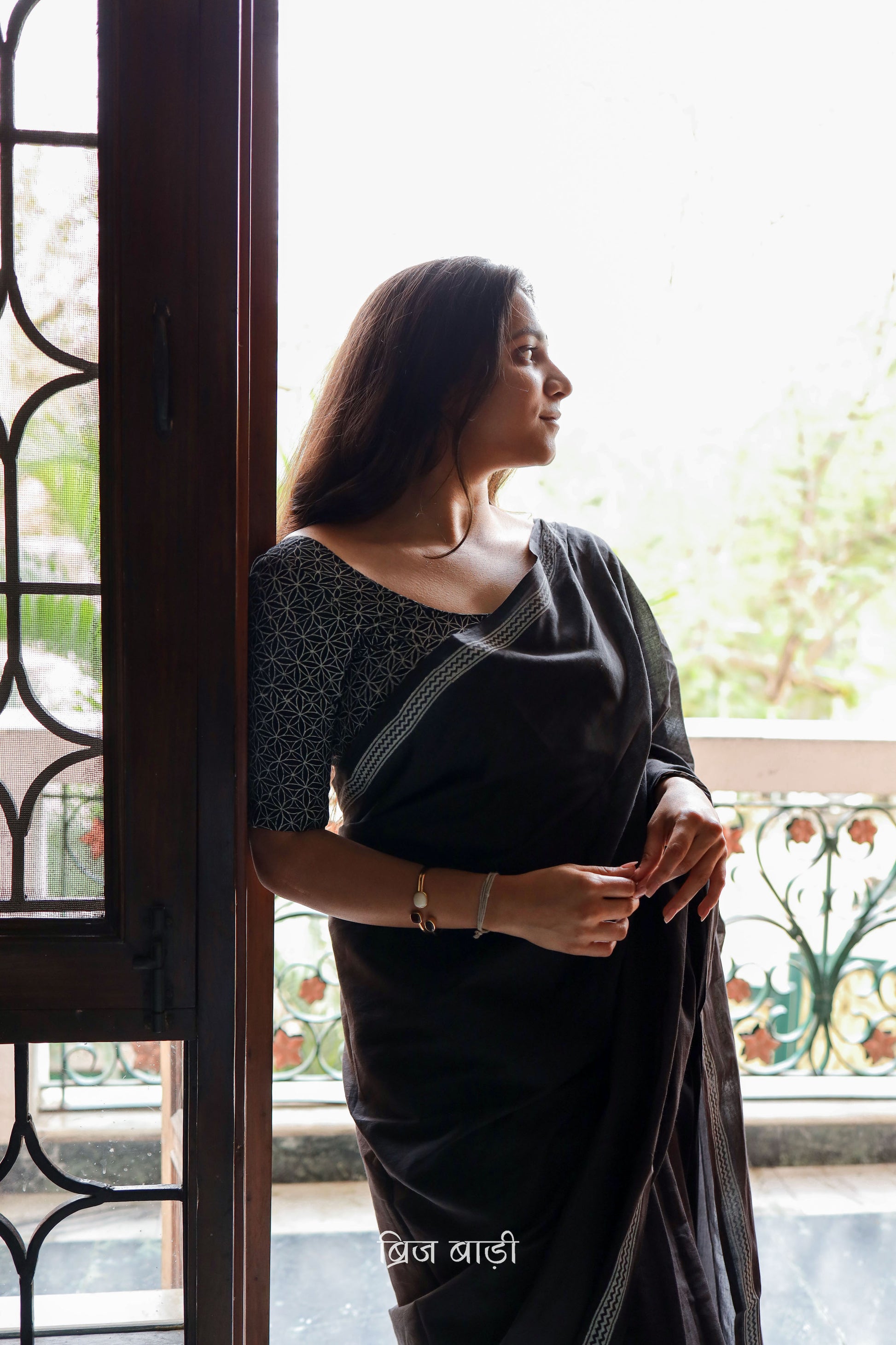 Black soft and light-weight cotton saree by Brij Bari with a simple and elegant hand block printed border in white for a timeless minimal look. Made from breathable, easy-to-drape cotton, this saree is perfect for everyday wear, offering effortless style & comfort. Pallu is finished with handmade mustard thread tassels, adding a handcrafted detail and a pop of colour. Includes a free hand block printed blouse piece designed to complement the sar the saree’s clean, classic border design. 