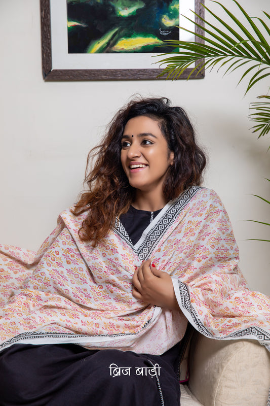 Off white soft and light-weight cotton dupatta by Brij Bari, beautifully hand block printed with a vibrant geometrical pattern in rich red and warm yellow tones. This eye-catching, artisanal design adds a lively and handcrafted touch to the elegant off-white base, making it a versatile accessory to pair with a range of suits, kurtas, or ethnic outfits. The dupatta is finished with olive green handmade thread tassels on the pallu, adding a subtle earthy contrast and a playful, artisanal finish. 