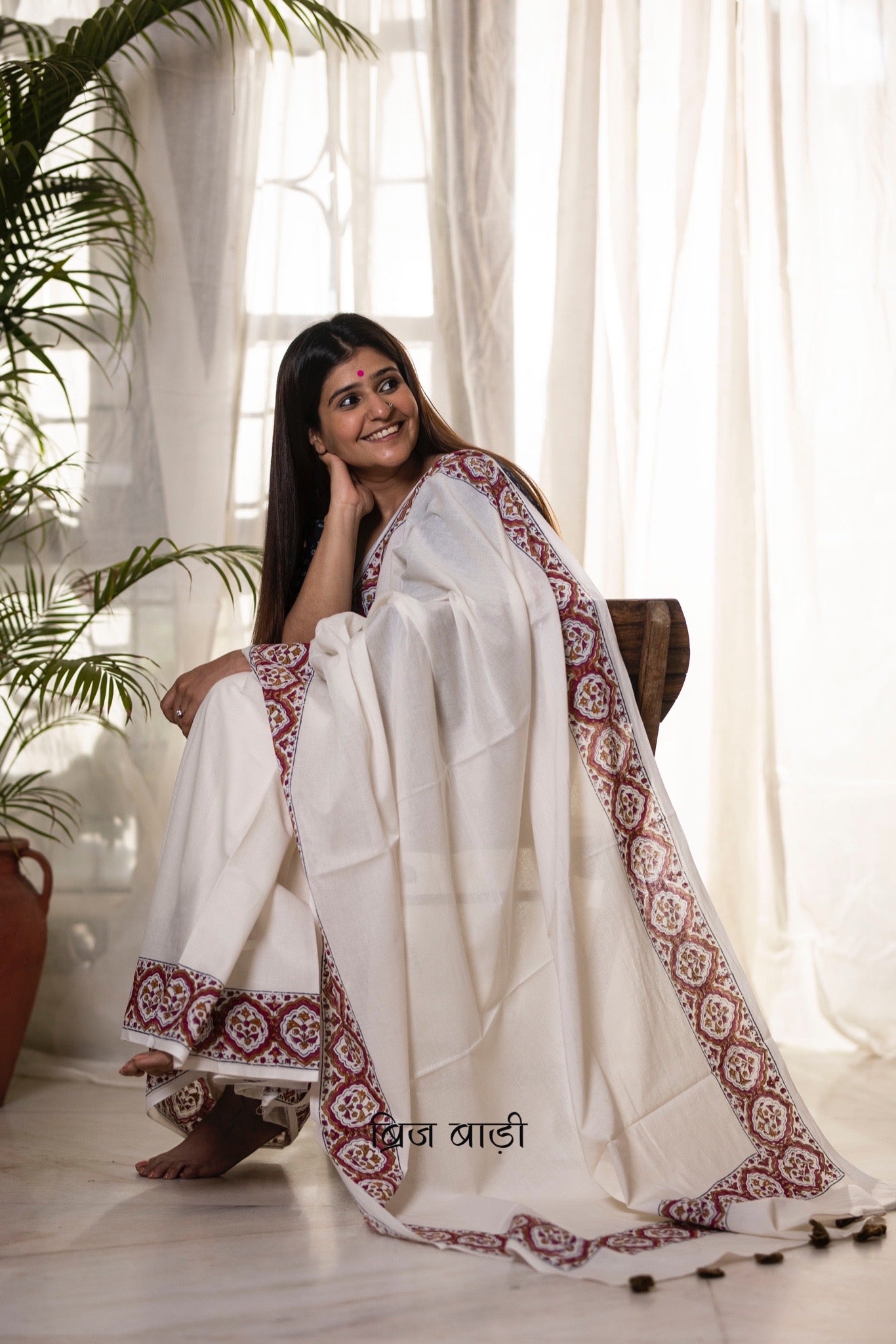 Off white soft and light-weight cotton saree by Brij Bari, featuring a delicate and intricate multicolour hand block printed border crafted by skilled artisans. Designed for all-day comfort and effortless style, this saree is detailed with olive green handmade thread tassels on the pallu. It comes with a free block printed blouse piece, making it a versatile pick for everyday wear, casual gatherings, and relaxed festive occasions. Free shipping pan India.