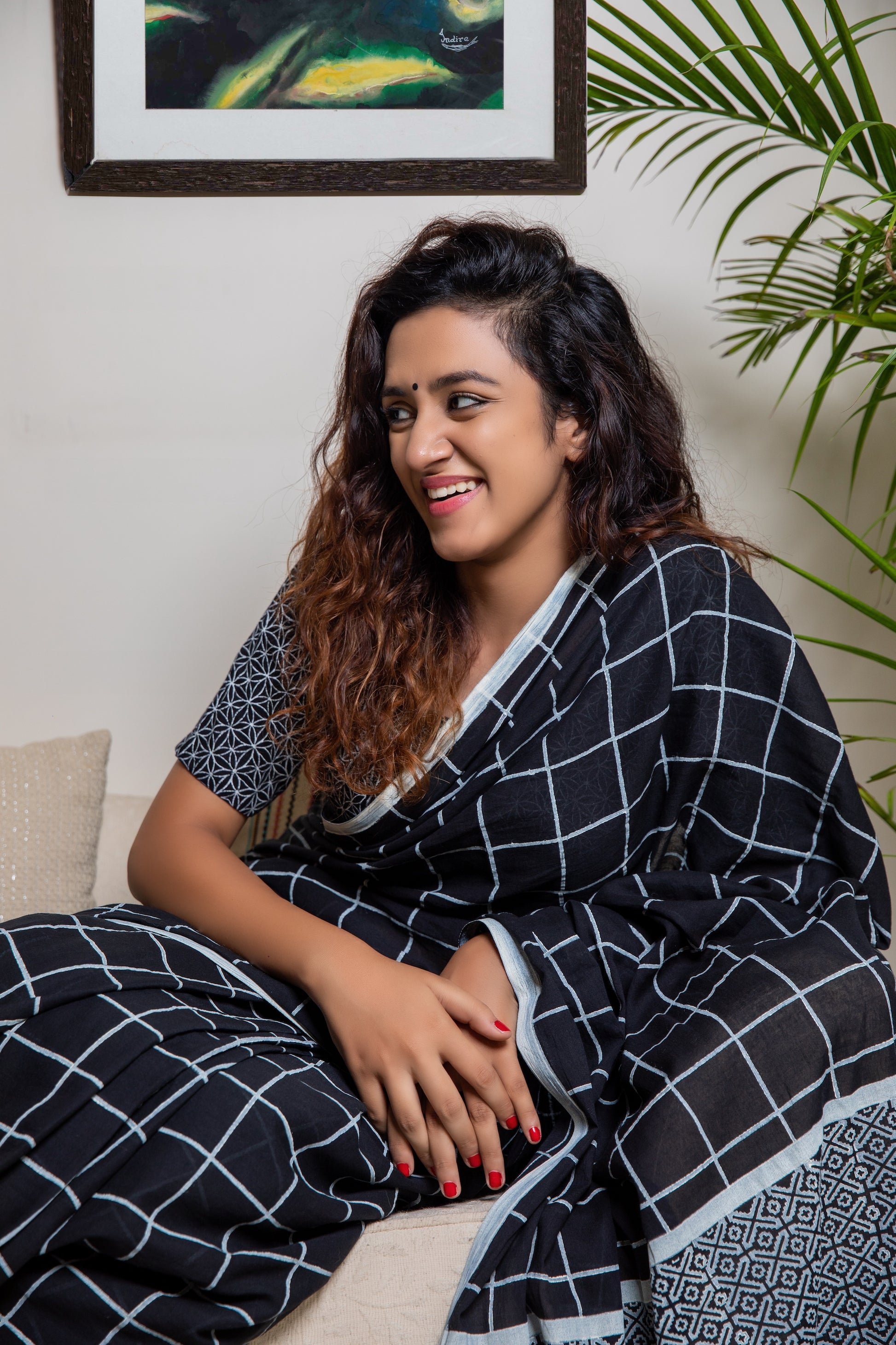 Black soft and light-weight cotton saree by Brij Bari, hand block printed in white with a classic check pattern on the body and a striking geometrical pattern on the pallu. Detailed with pink handmade thread tassels that add a charming, handcrafted touch. This saree comes with a free matching block printed blouse piece, offering a complete, artisanal look. A versatile, breathable saree perfect for everyday wear, casual outings, or semi-formal occasions, with free shipping pan India. Available in 2 colours