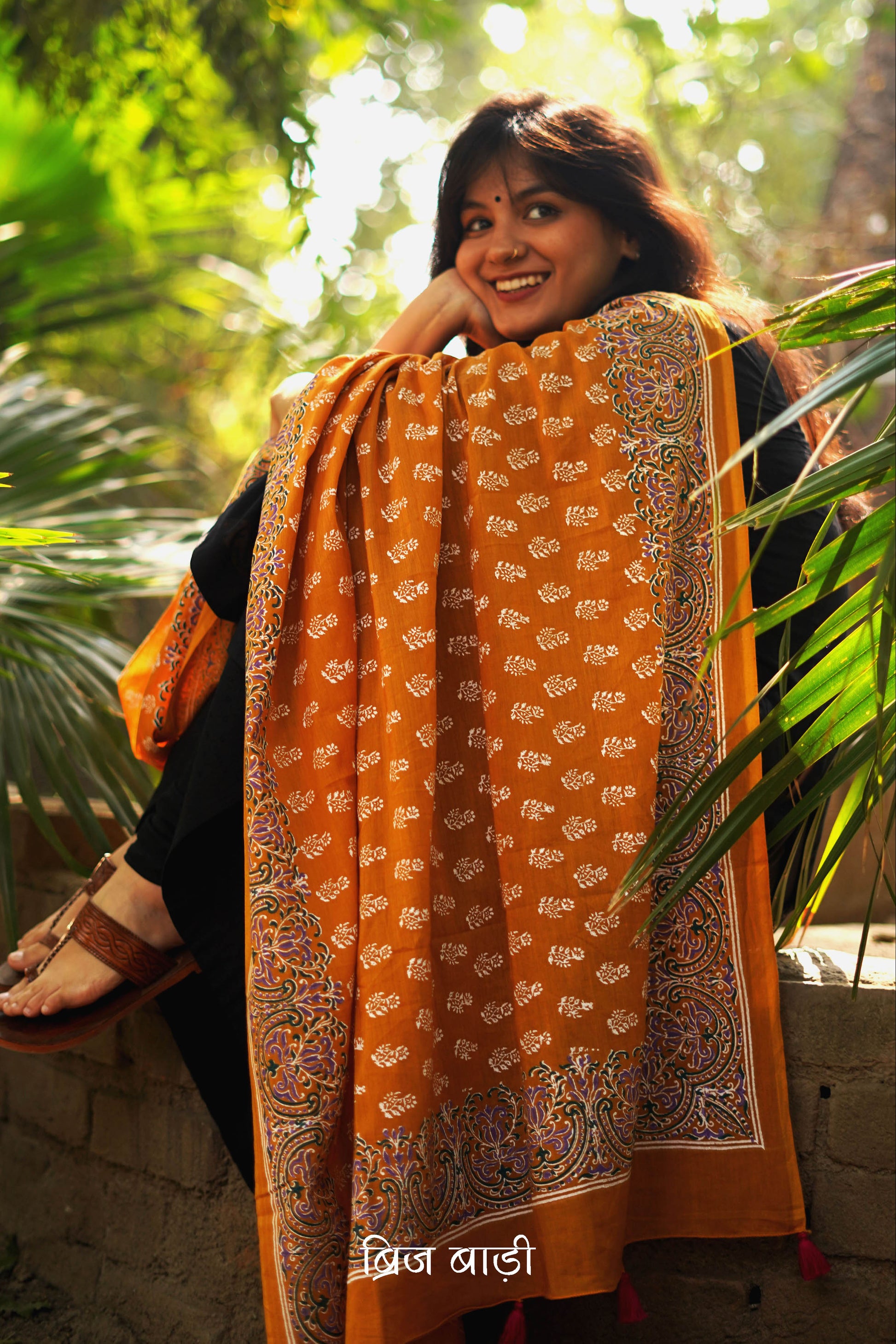 Ochre yellow soft and lightweight cotton dupatta by Brij Bari, hand block printed with a charming floral motif pattern for an artisanal touch. Accented with pink handmade thread tassels on both ends of the pallu, this versatile dupatta adds a vibrant pop to your daily suits, offering breathable comfort and effortless style for all-day wear. Free shipping pan India.