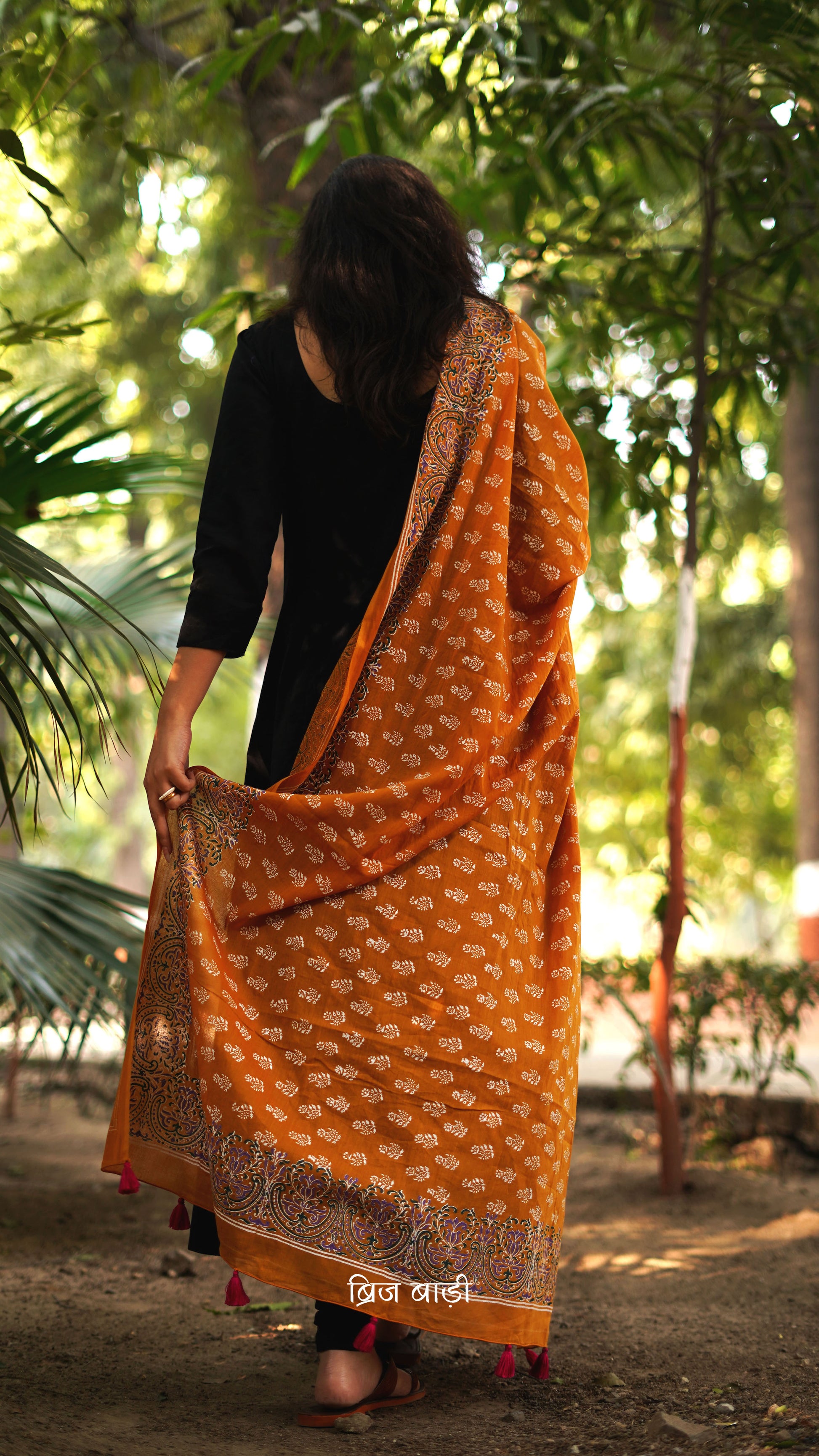Ochre yellow soft and lightweight cotton dupatta by Brij Bari, hand block printed with a charming floral motif pattern for an artisanal touch. Accented with pink handmade thread tassels on both ends of the pallu, this versatile dupatta adds a vibrant pop to your daily suits, offering breathable comfort and effortless style for all-day wear. Free shipping pan India.