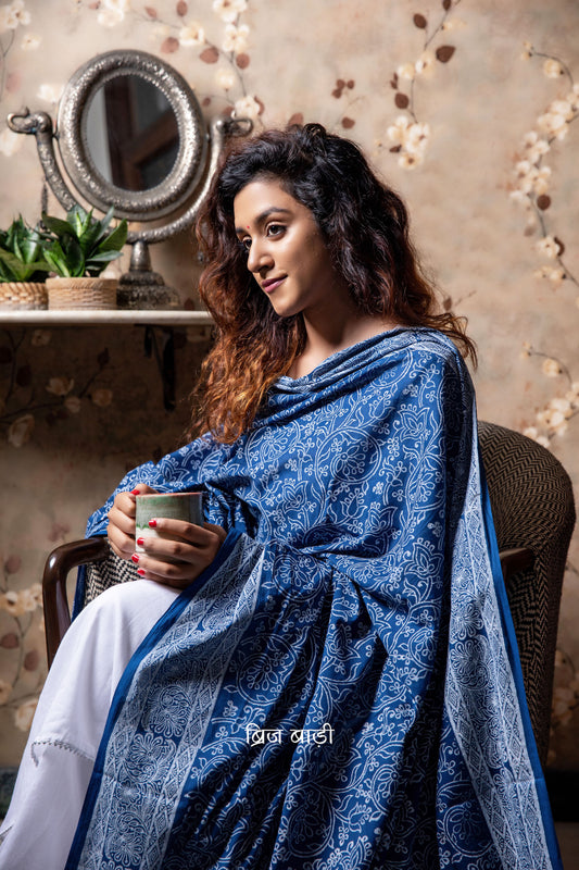 Blue soft and light-weight cotton dupatta by Brij Bari hand block printed with a delicate floral pattern in classic white, offering a timeless, elegant look. Crafted in breathable cotton, this dupatta is perfect to pair with suits, kurtas, or casual ethnic wear adding a fresh, handcrafted charm to everyday and festive outfits. The pallu is adorned with vibrant red handmade thread tassels, lending a playful, artisanal touch. Its versatile design makes it suitable for both everyday wear and special occasion. 