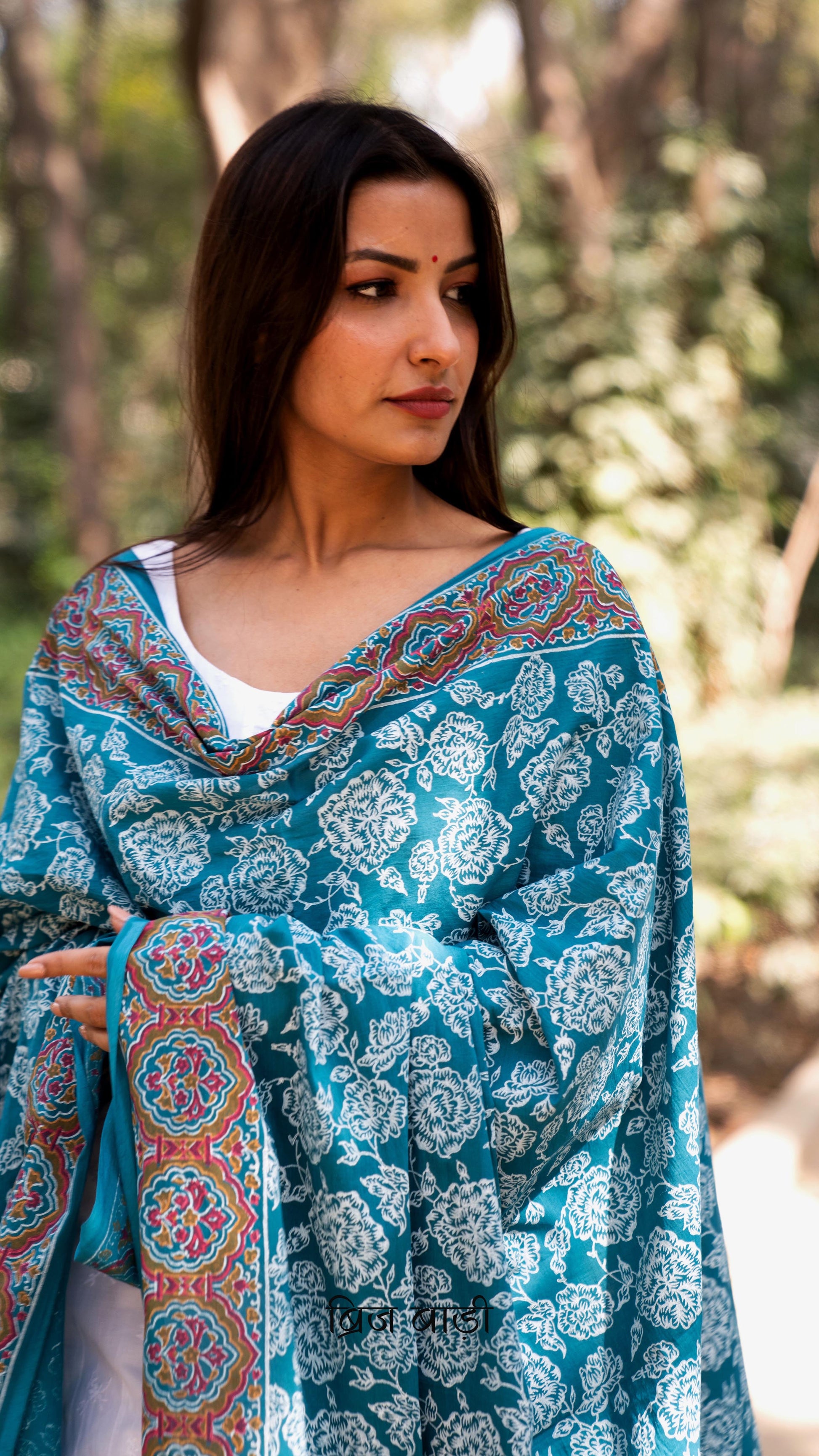 Teal blue soft and lightweight cotton dupatta by Brij Bari, hand block printed with elegant floral motifs across the body and a striking multicolour border. Accentuated with handmade light green thread tassels on both ends of the pallu, this dupatta brings a vibrant, artisanal touch to your everyday suits while offering breathable comfort and versatile styling. Free shipping pan India.