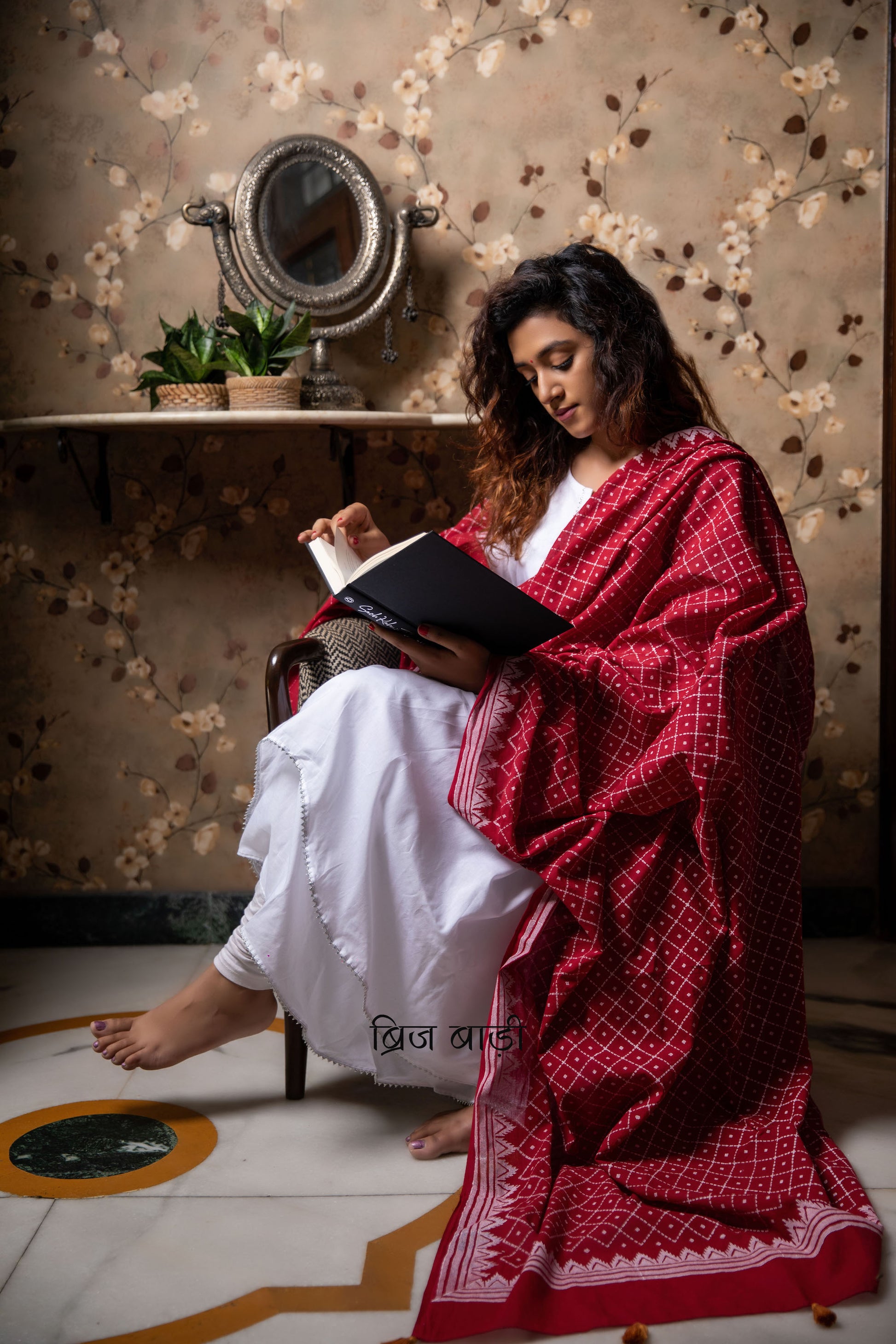 Deep red soft and light-weight cotton dupatta by Brij Bari, featuring a striking geometrical pattern hand block printed in  white,adding a bold modern touch to a classic silhouette. Made from breathable, airy cotton fabric, this dupatta is perfect to pair with a variety of suits, kurtas, or everyday ethnic ensembles, lending a handcrafted, artisanal elegance. The pallu is finished with rich mustard handmade thread tassels, providing a warm contrast and a playful, traditional flair.