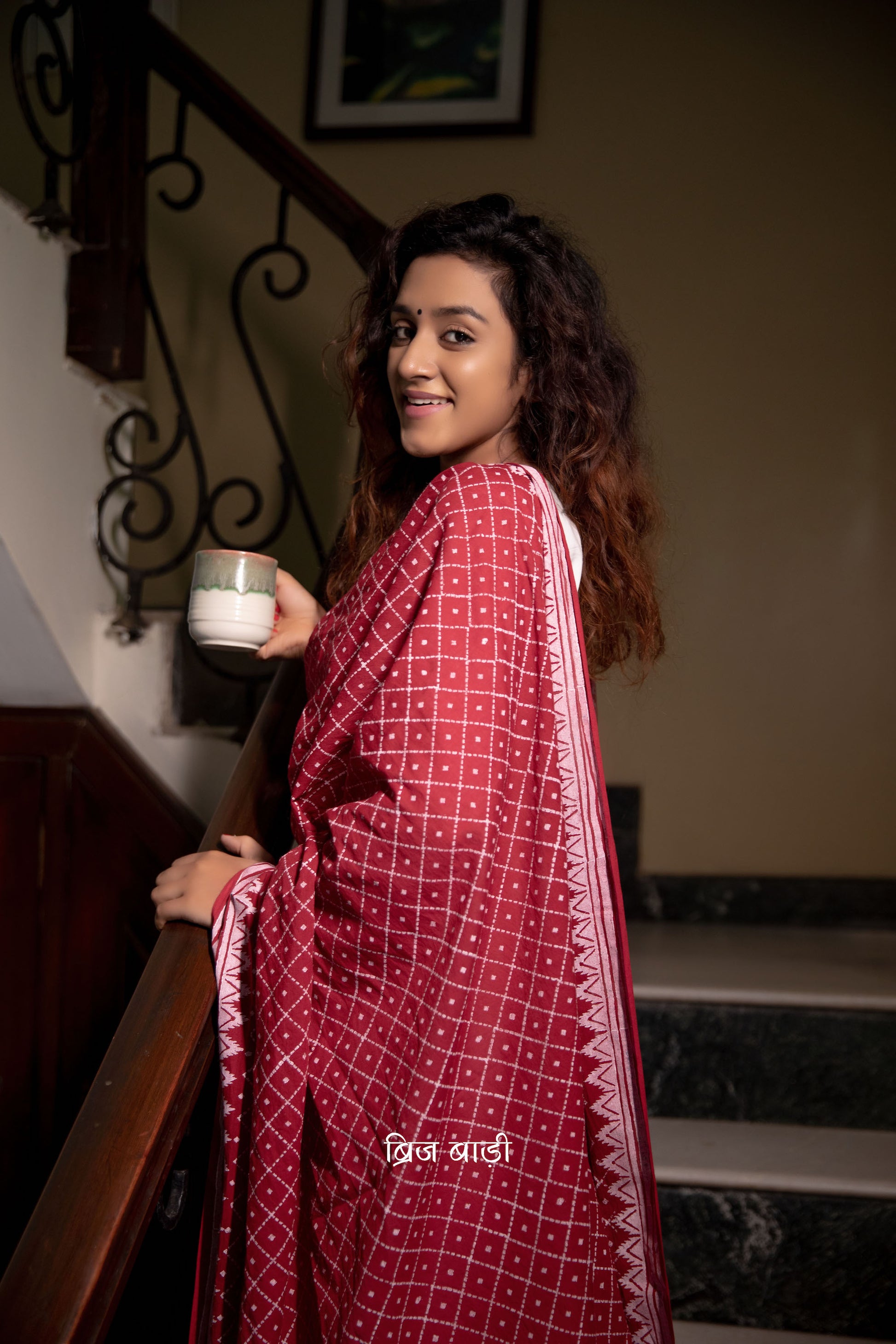 Deep red soft and light-weight cotton dupatta by Brij Bari, featuring a striking geometrical pattern hand block printed in  white,adding a bold modern touch to a classic silhouette. Made from breathable, airy cotton fabric, this dupatta is perfect to pair with a variety of suits, kurtas, or everyday ethnic ensembles, lending a handcrafted, artisanal elegance. The pallu is finished with rich mustard handmade thread tassels, providing a warm contrast and a playful, traditional flair.